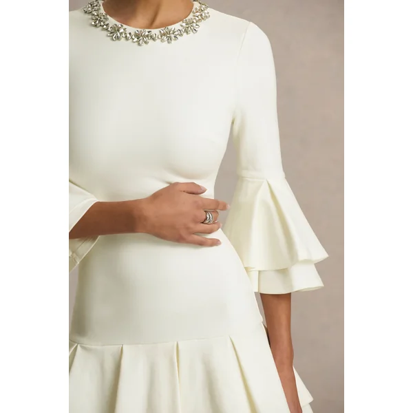 Mirna | Mini-robe crème à encolure ras-du-cou avec manches évasées et détails volantés